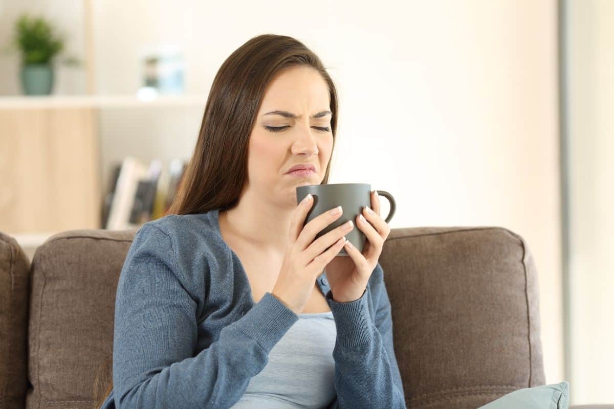 woman reacting on tasting bad coffee.