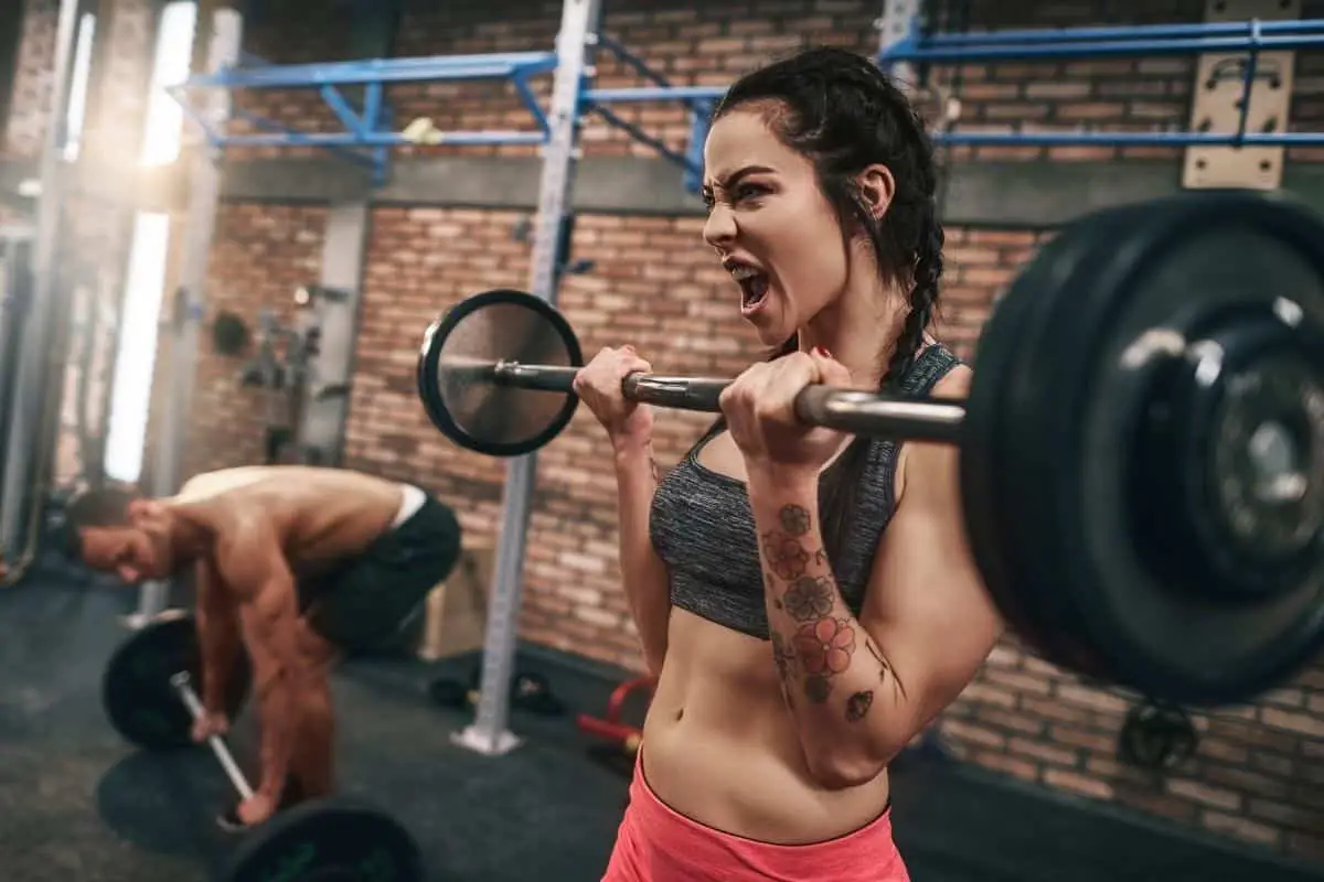 man and woman exercising at gym after having pre-workout coffee.