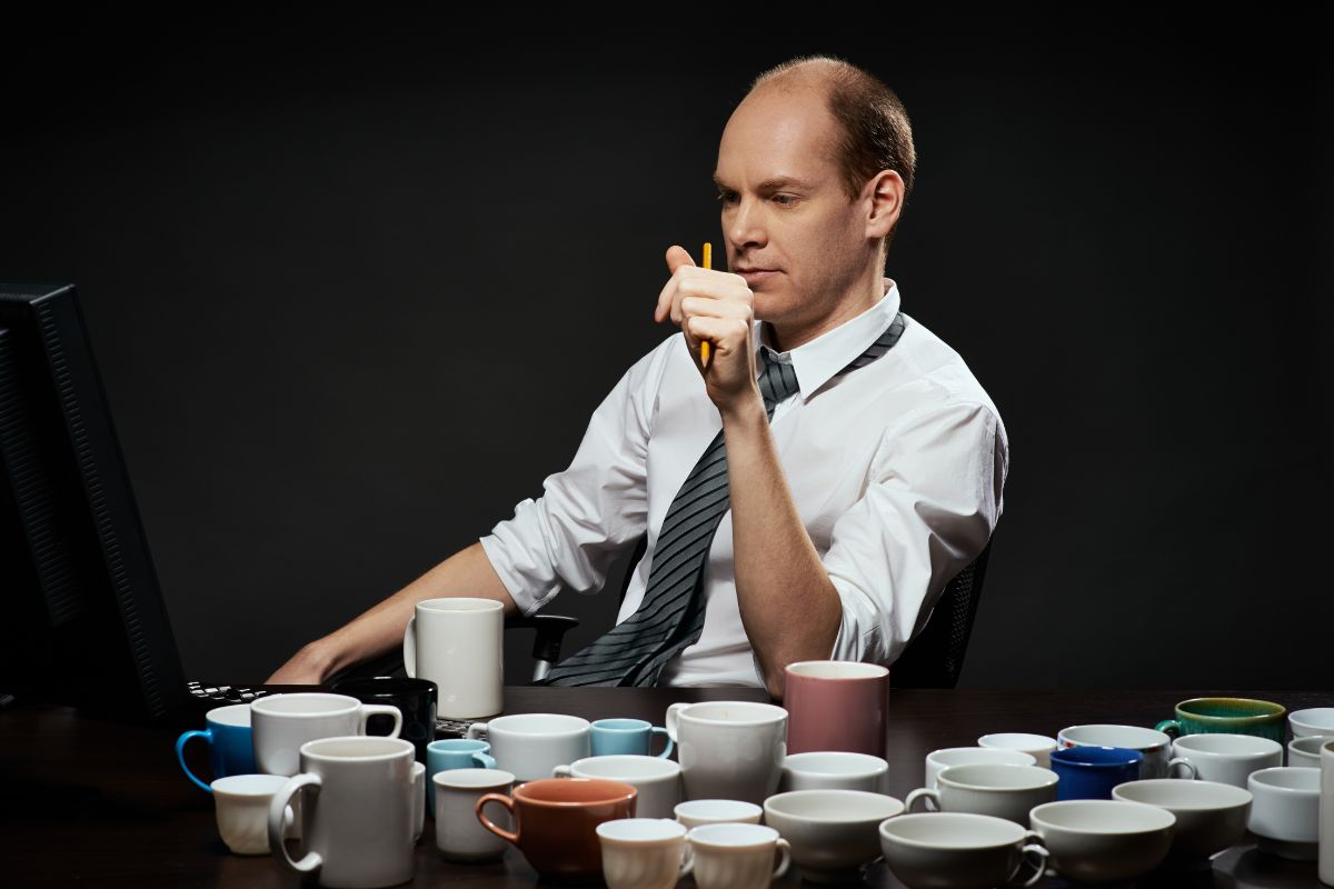 man drinking a lot of coffee while at work