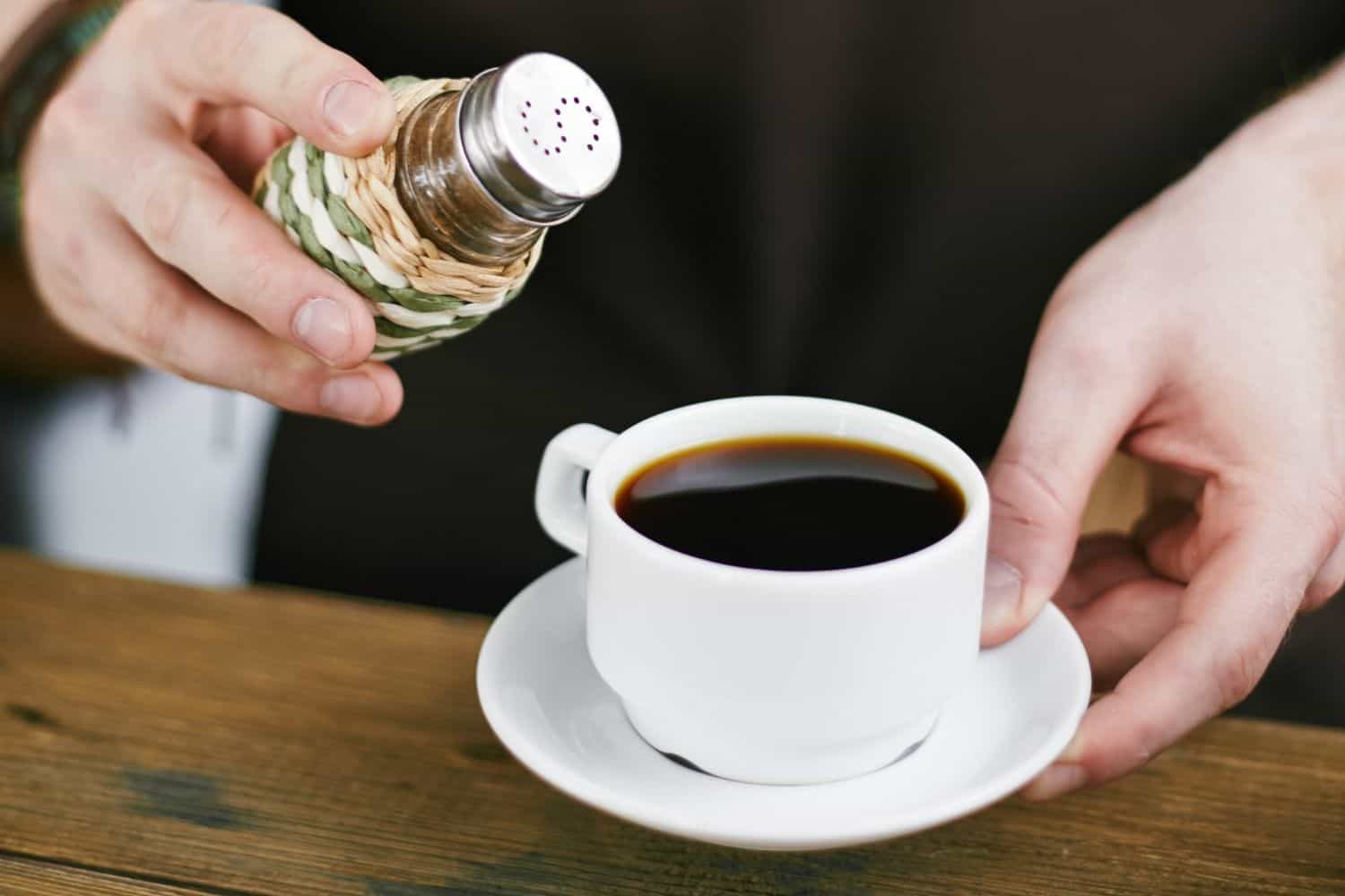 barista adding salt to coffee.