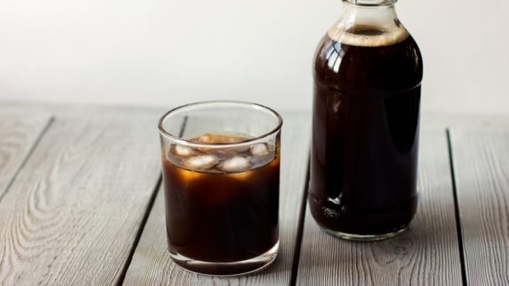 iced cold brew coffee in a bottle and in a glass.