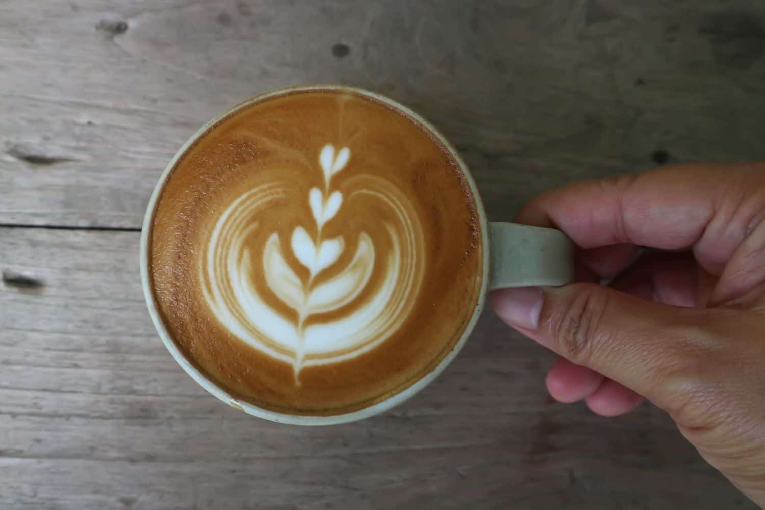 man holding a cup of hot coffee.