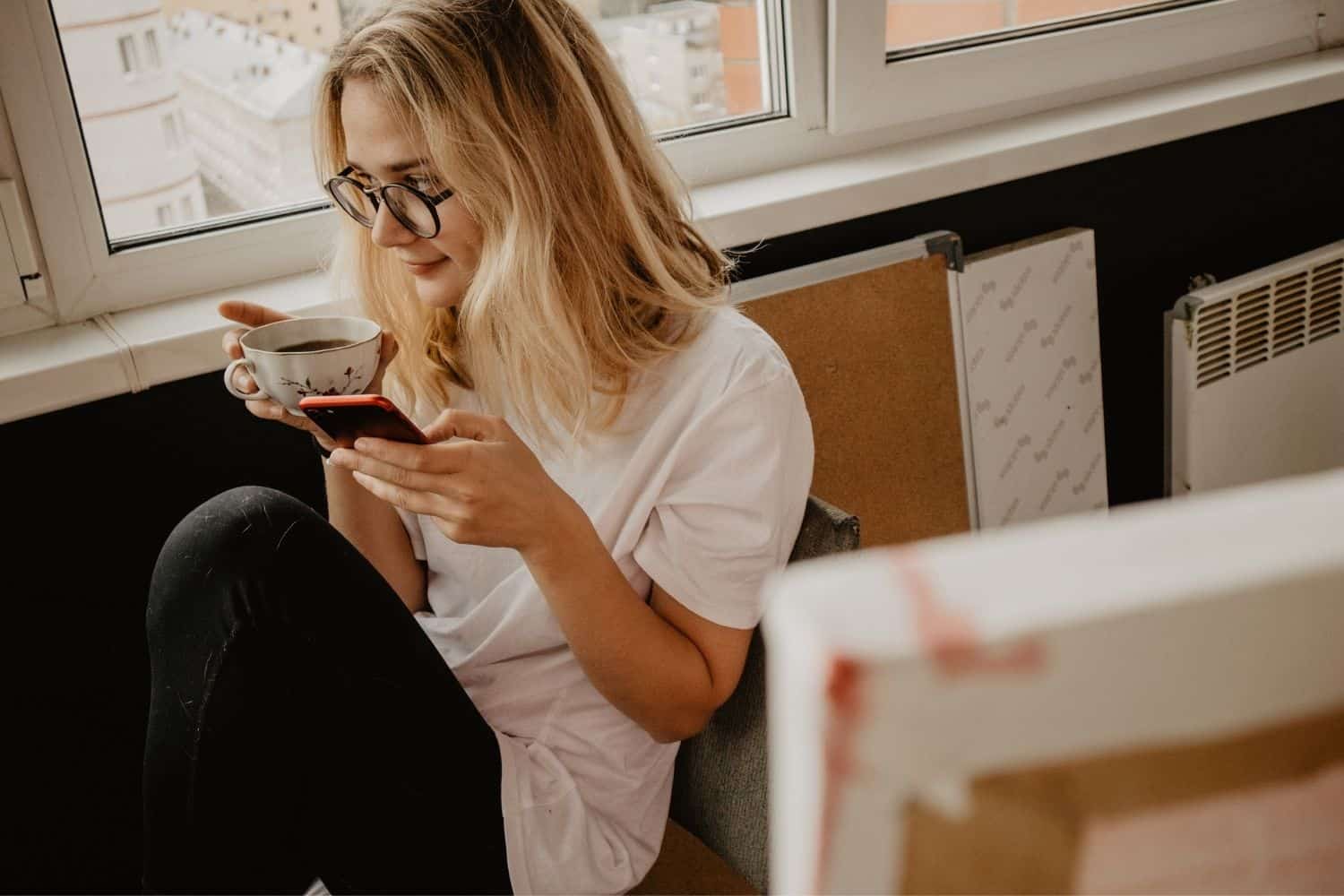 woman checking the advantages and disadvantages of coffee on her phone.