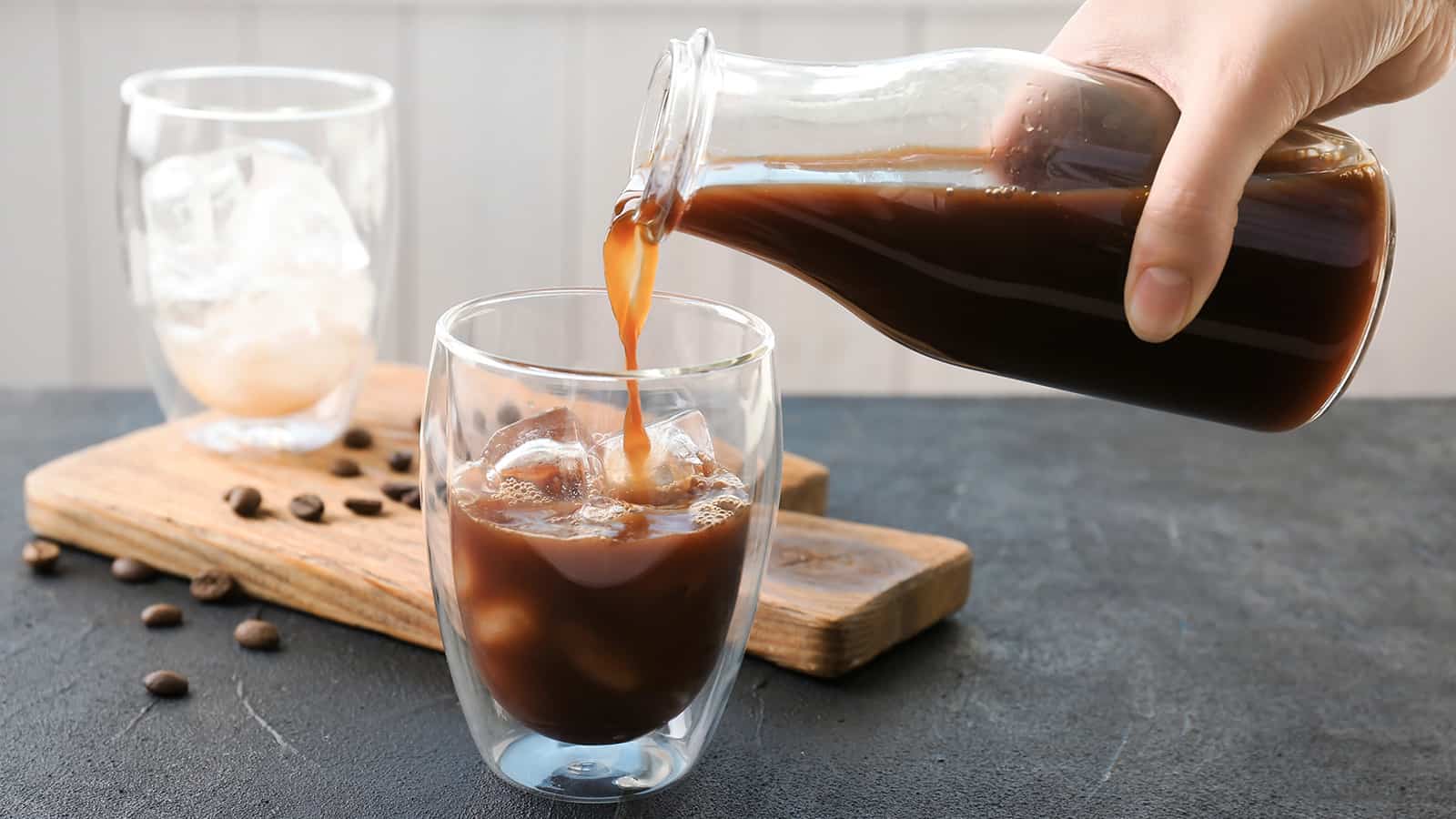 woman pouring cold brew coffee into a glass.