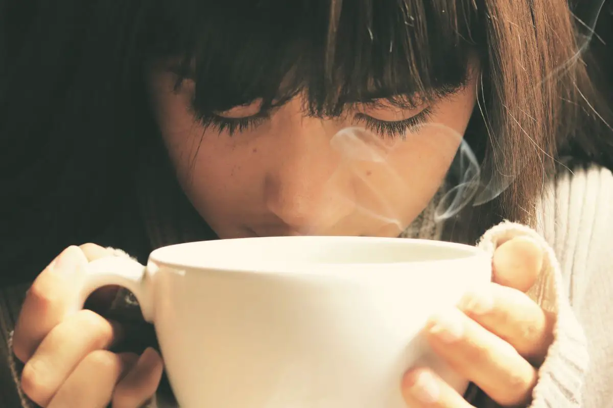 woman sipping on a cup of coffee