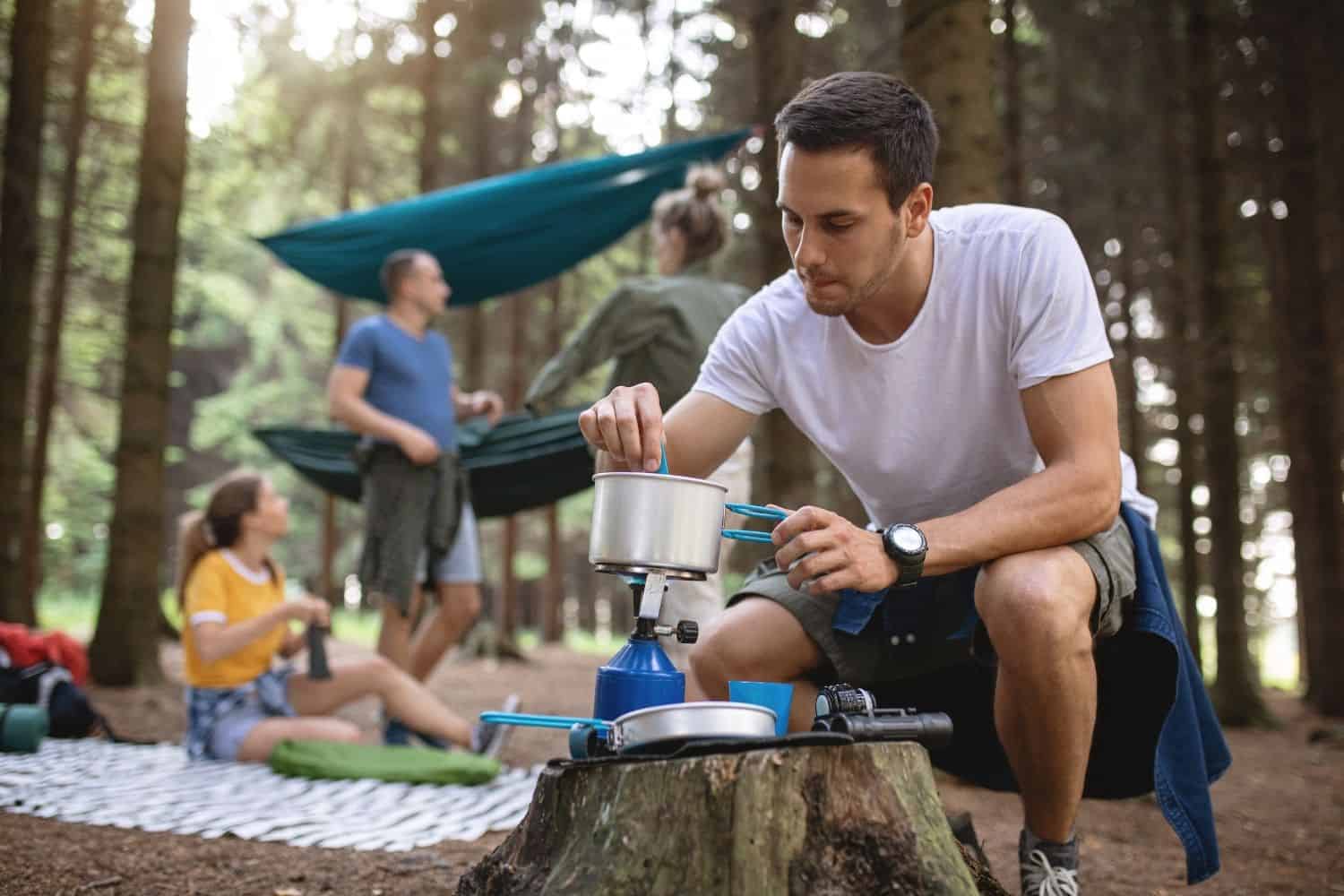 man brewing cowboy coffee while camping.