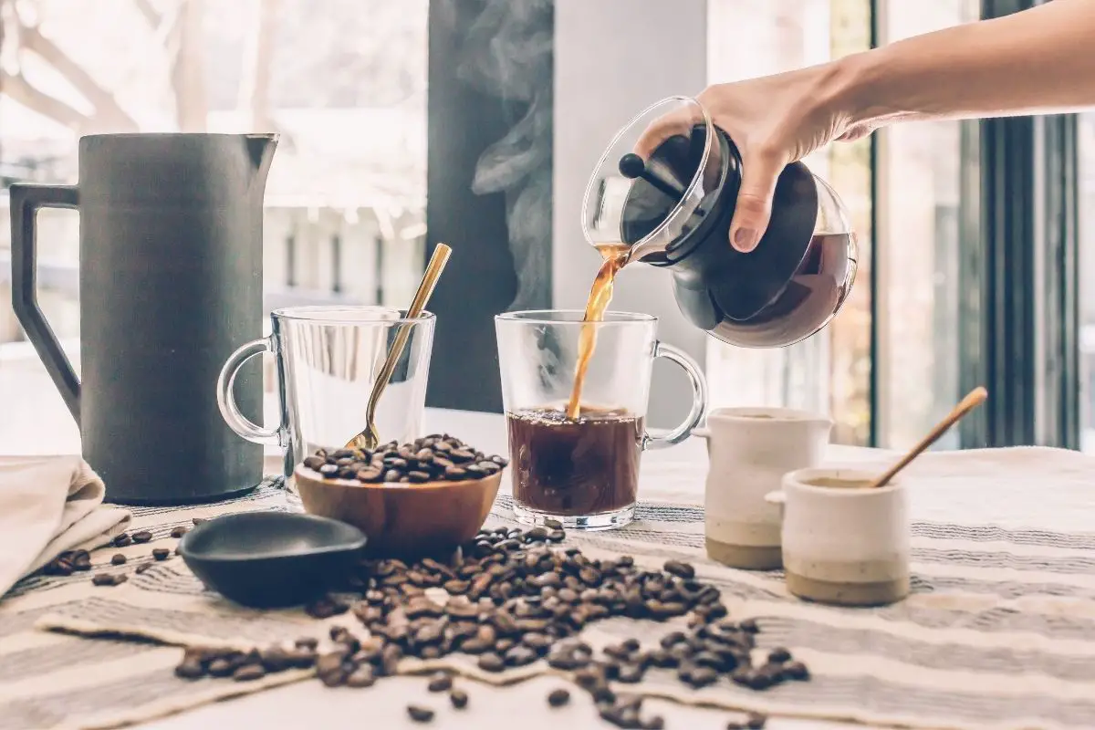 woman pouring freshly brewed coffee into a cup