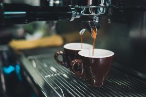 pouring coffee into the cup from coffee machine