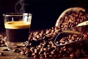 coffee beans and hot coffee in white mug