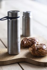 stainless steel vacuum flask beside brown cookies on brown wooden