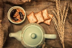 white ceramic teapot beside brown and white food on while ceramic