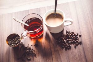 two cup of coffee and tea with coffee beans and tea leaf